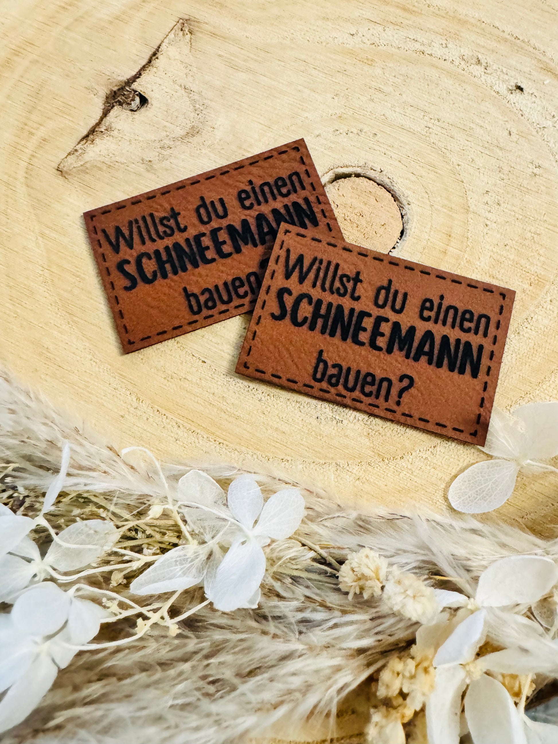 braunes Kunstlederlabel mit dem Spruch Willst du einen Schneemann bauen Fragezeichen