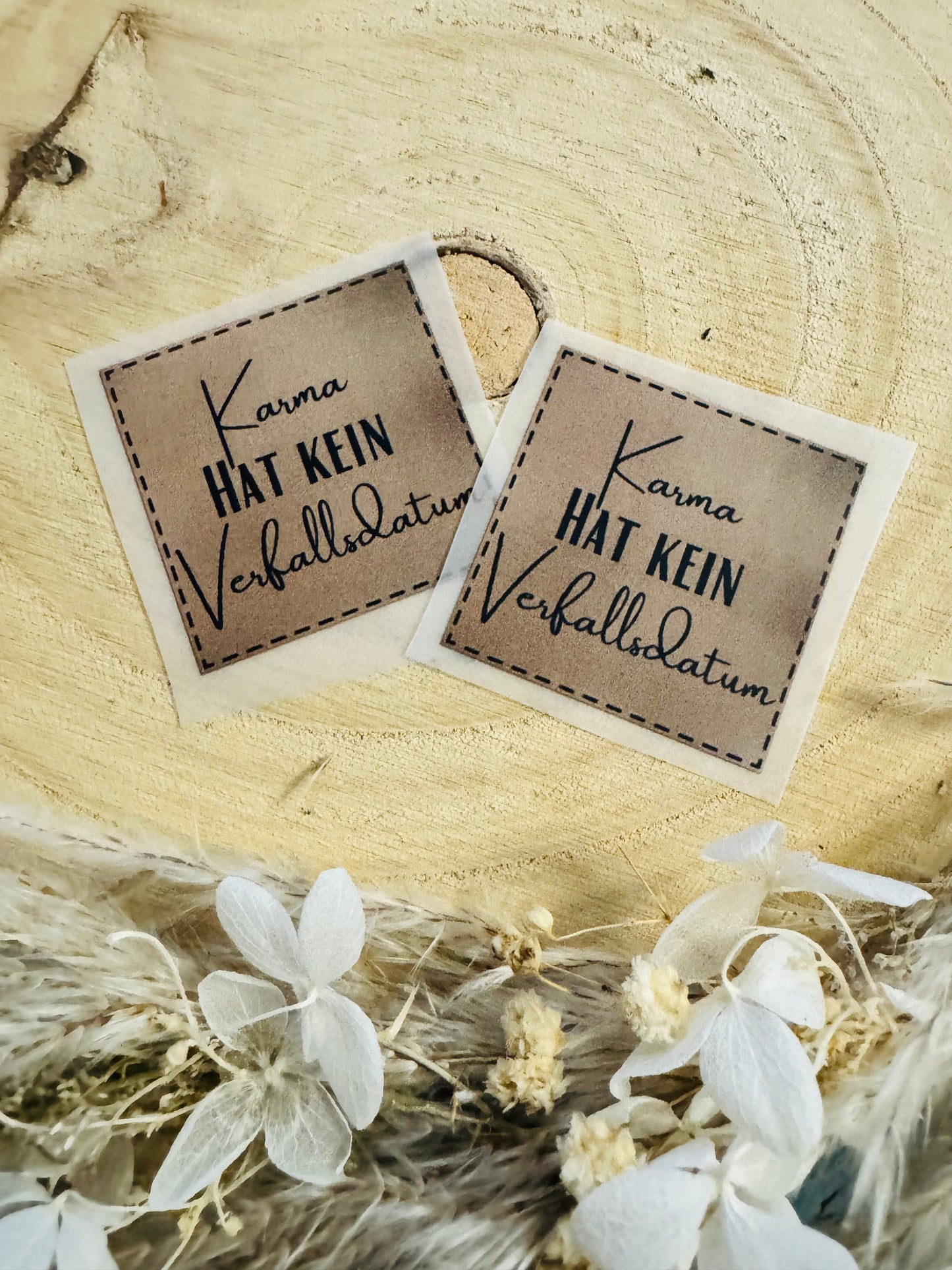 hellbraunes Bügellabel mit dem Spruch Karma hat kein Verfallsdatum in schwarzer Schrift
