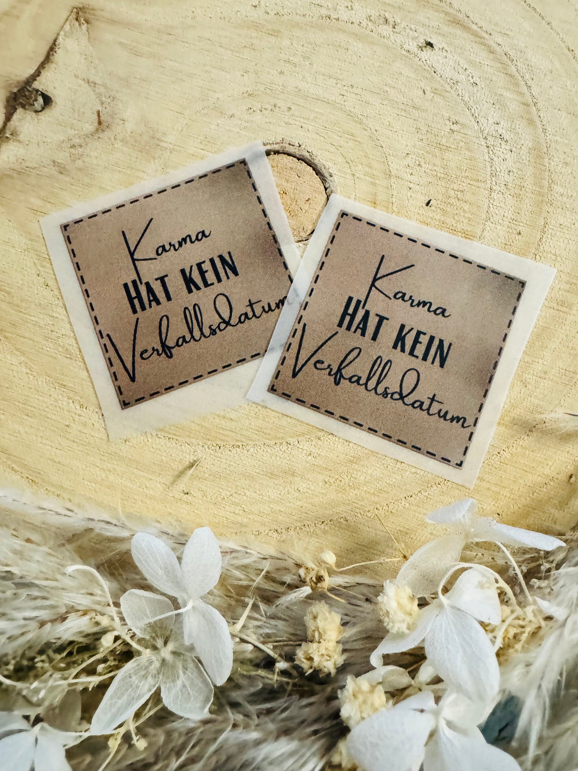 hellbraunes Bügellabel mit dem Spruch Karma hat kein Verfallsdatum in schwarzer Schrift