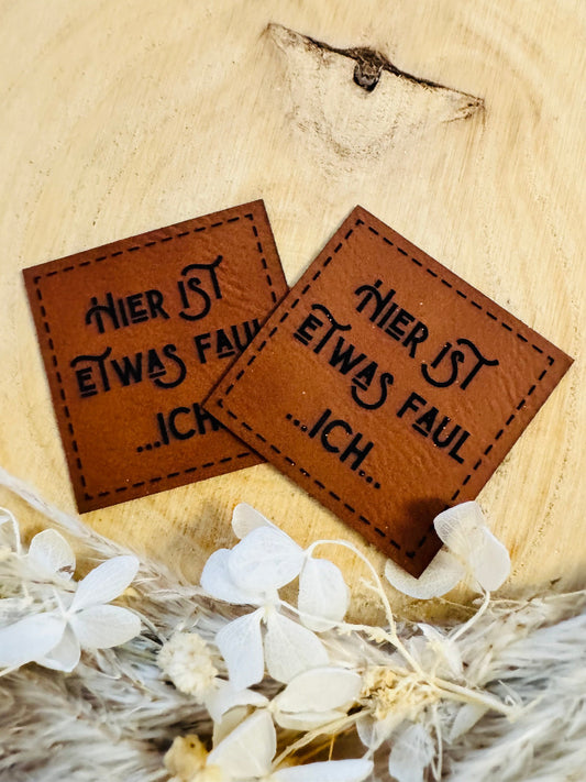 superweiches braunes Kunstlederlabel mit dem Spruch Hier ist etwas faul Punkt punkt Punkt Ich Punkt Punkt Punkt