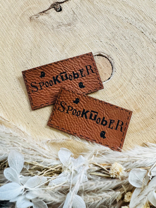 superweiches braunes Kunstleder Label mit dem Wort Spooktober und einem kleinen Halloween monsterchen
