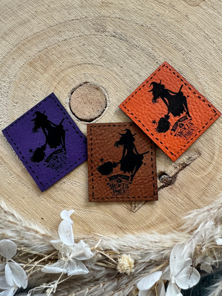 tolle Kunstlederlabel in drei Farben mit deiner kleinen Hexe uf dem Besenstiel und dem Spruch Hocus Pocus