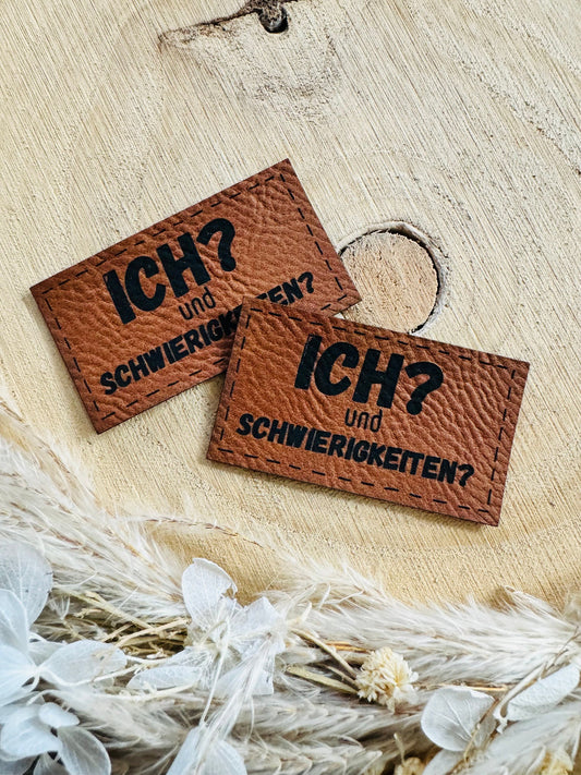 superweiches braunes Kunstleder Label mit dem Spruch Ich Fragezeichen und Schwierigkeiten Fragezeichen in schwarzer Schrift