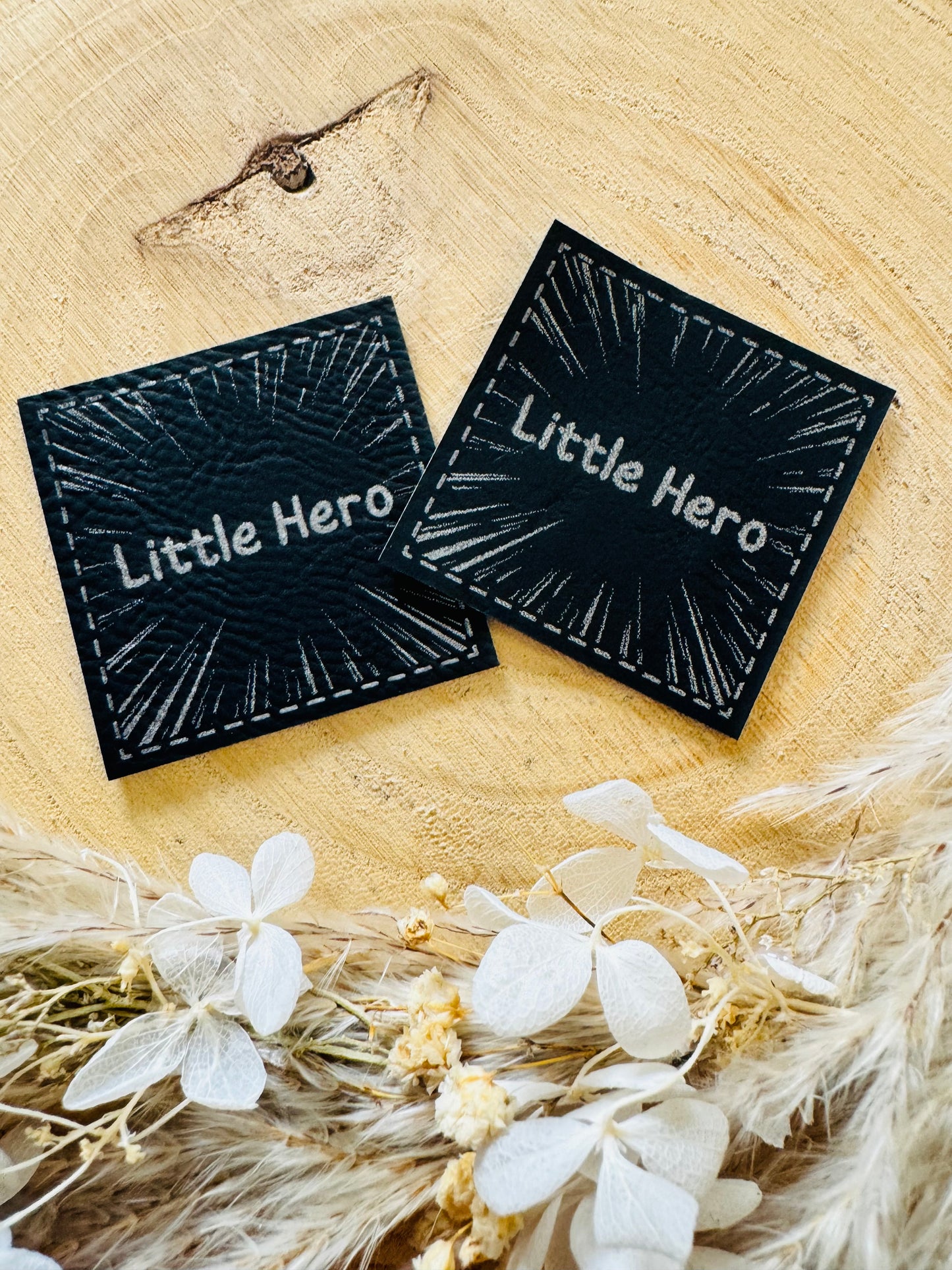 schwarzes kunstlederlabel mit dem spruch little hero