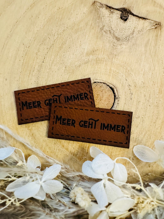 braunes kunstlederlabel mit dem spruch meer geht immer