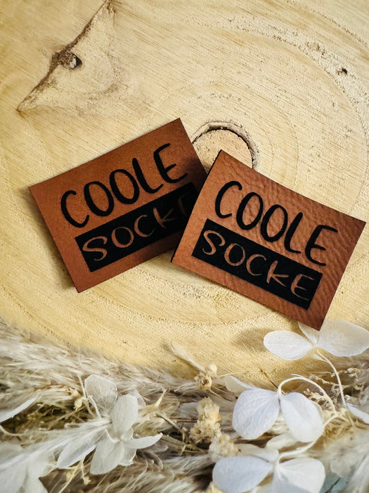 superweiches braunes Kunstlederlabel mit dem Spruch Coole Socke
