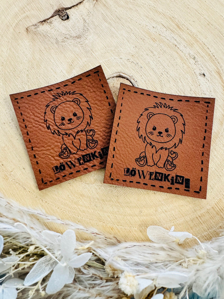 superweiches braunes Kunstlederlabel mit dem Spruch Löwenkind und einem sitzenden Löwen abgebildet