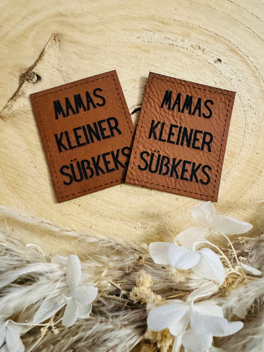 braunes Kunstlederlabel mit dem Spruch Mamas kleiner Süßkeks
