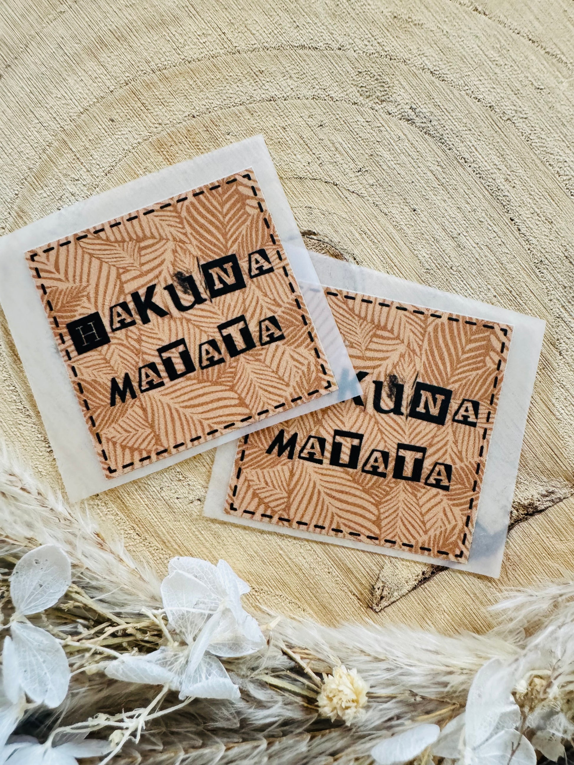 braun gemustertes Bügellabel Etikett mit dem Spruch Hakuna Matata in schwarzer Schrift