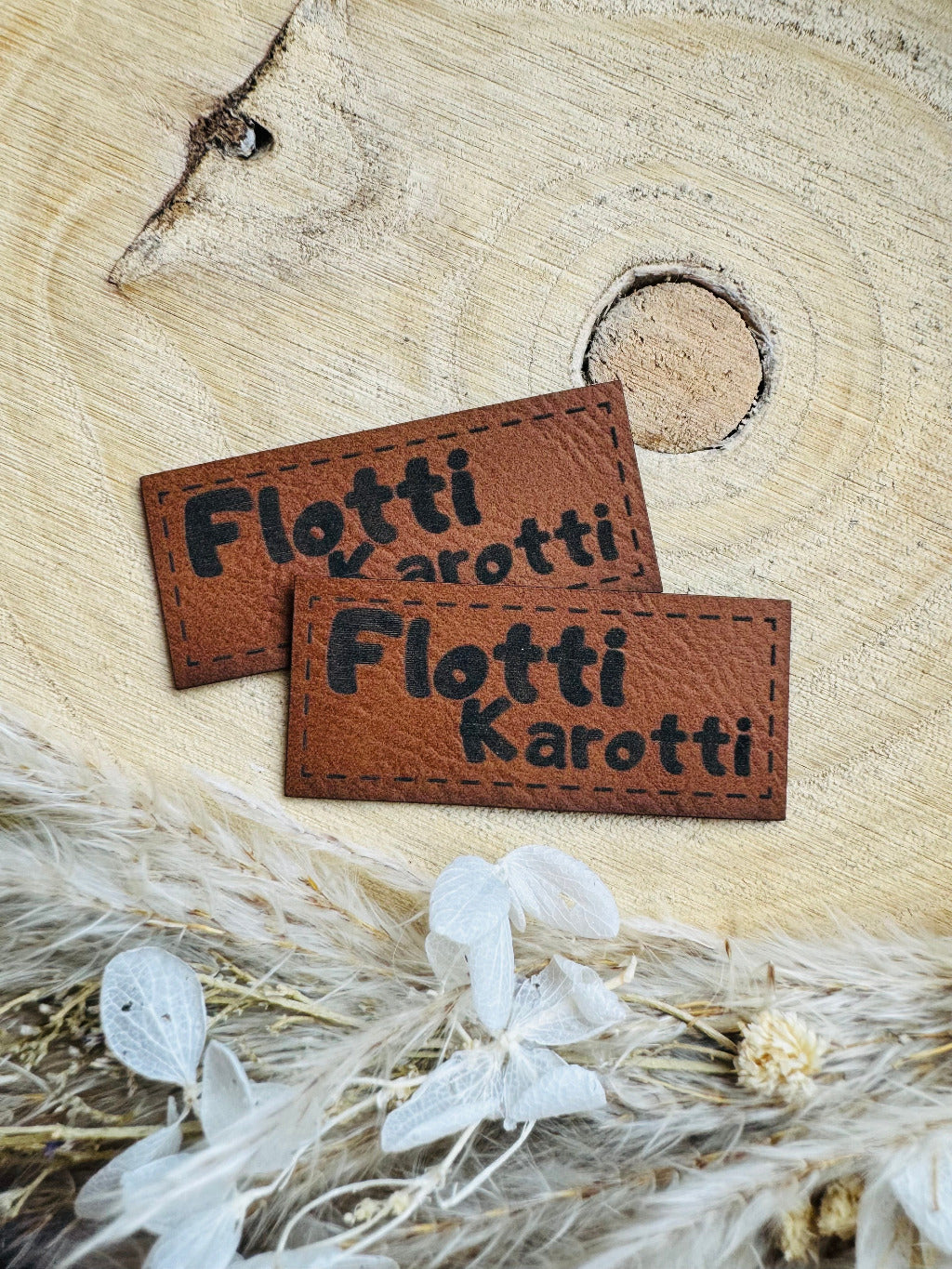 braunes Kunstlederlabel mit dem Spruch Flotti Karotti in schwarzen Buchstaben