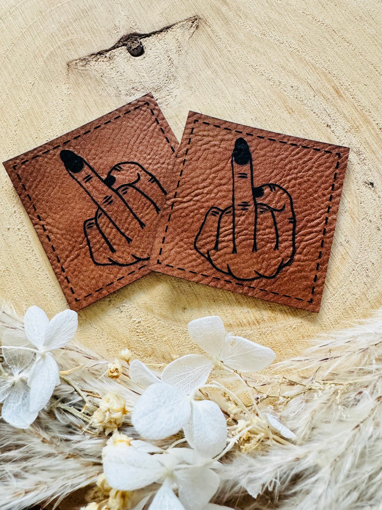 superweiches braunes Kunstlederlabel mit einem abgebildeten Stinkefinger in schwarz