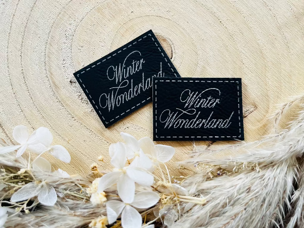 schwarzes Kunstlederlabel mit dem Spruch Winter Wonderland in silberner Schrift