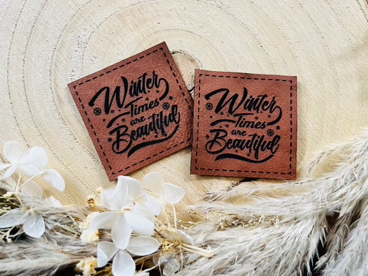 braunes Kunstlederlabel mit dem Spruch Winter Times are Beautyful