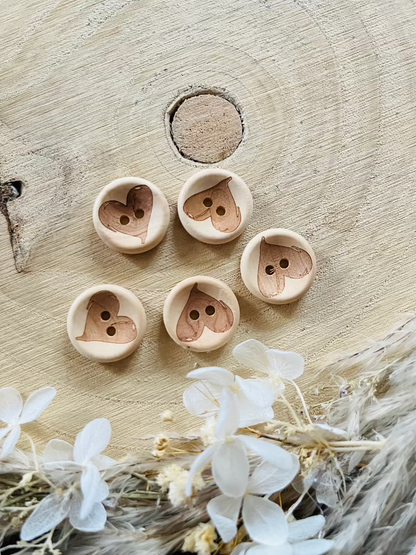 Holzknopf rund mit einem Herzen abgebildet