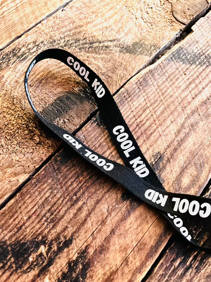 Baumwoll Webband mit Spruch Cool Kid auf schwarzem Untergrund, Breite 12 Millimeter