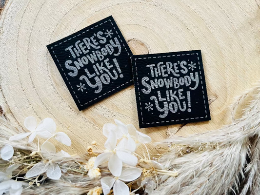 schwarzes Kunstlederlabel mit dem Spruch There is Snowbody like You Ausrufezeichen in silberner Schrift