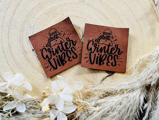 braunes Kunstlederlabel mit einem Schneemann und dem Spruch Winter Vibes