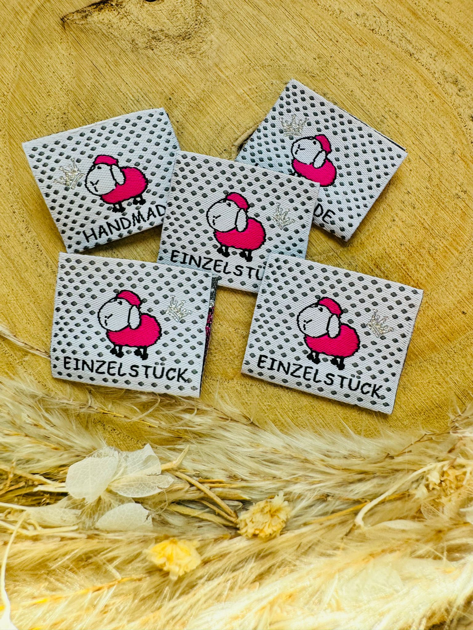 weiss gepunktetes Weblabel mit einem kleinen rosa Schäfchen und den Sprüchen Handmade und Einzelstück
