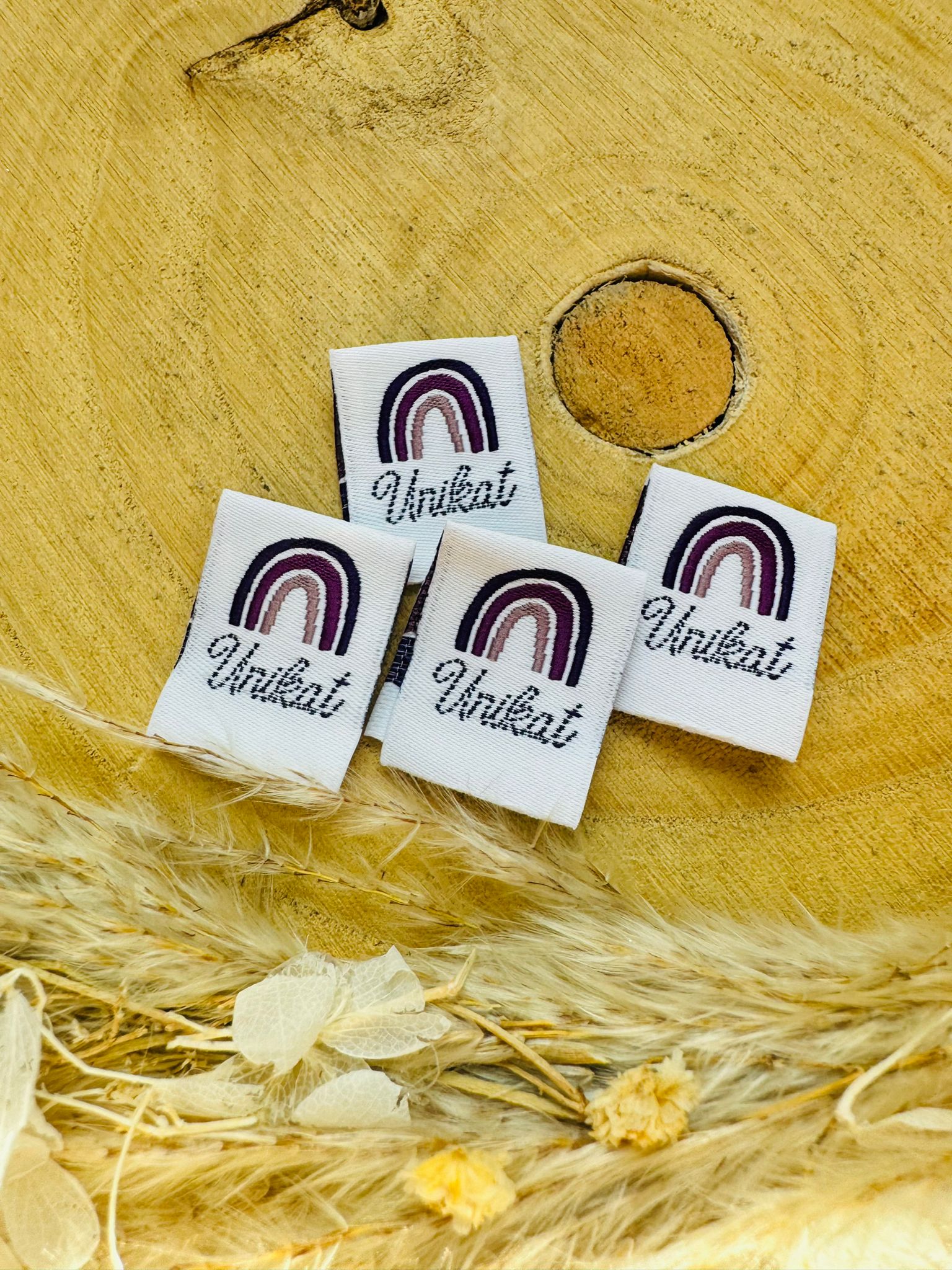 weisses Weblabel mit einem regenbogen in violetten Farben und dem Spruch Unikat