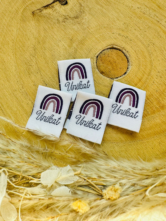 weisses Weblabel mit einem regenbogen in violetten Farben und dem Spruch Unikat