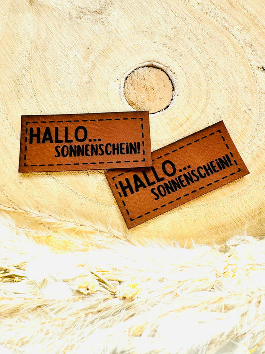braunes PU-Label mit dem Spruch HALLO Sonnenschein Ausrufezeichen