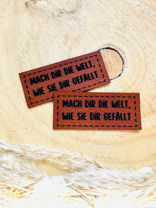 braunes PU-Label mit dem Spruch Mach Dir die Welt, wie Sie Dir gefällt Ausrufezeichen