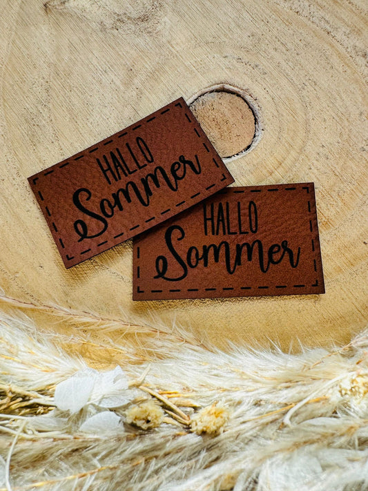 braunes PU-Label mit dem Spruch Hallo Sommer in schwarzer Schrift
