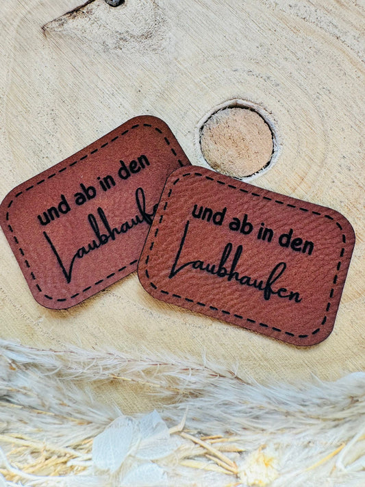braunes PU-Label mit dem Spruch und ab in den Laubhaufen