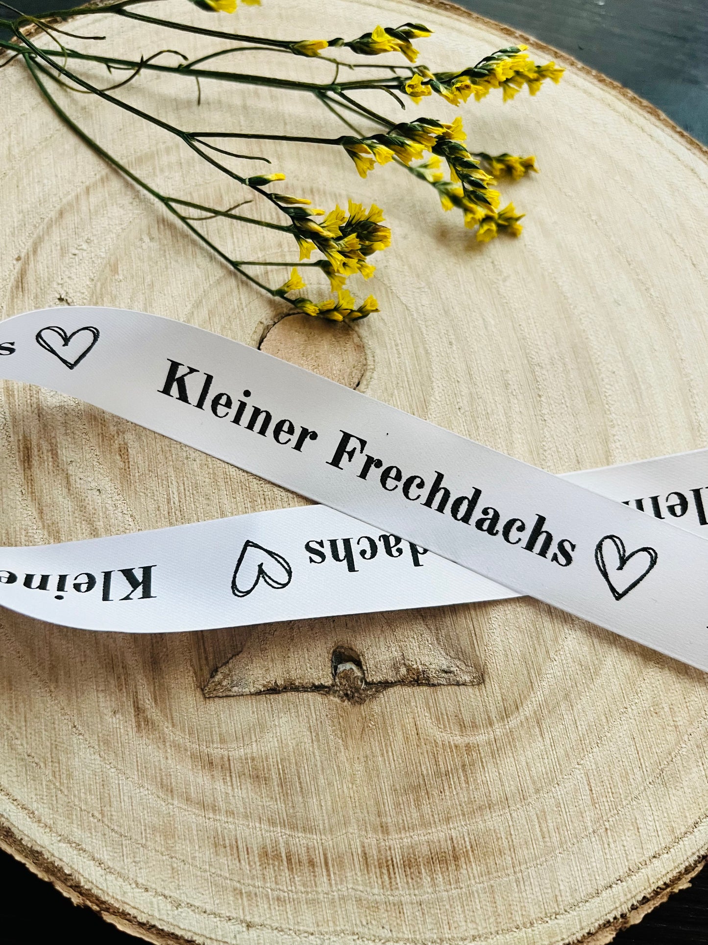 schönes weisses Satinband mit dem fortlaufenden Spruch Kleiner Frechdachs und kleinen Herzen, Breite 2 Zentimeter.