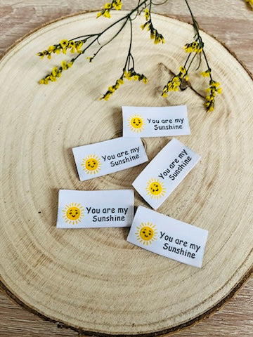 weisses Weblabel mit dem Spruch You are my Sunshine in schwarzer Schrift ind einer gelb leuchtenden Sonne mit einem lächelndem Gesicht