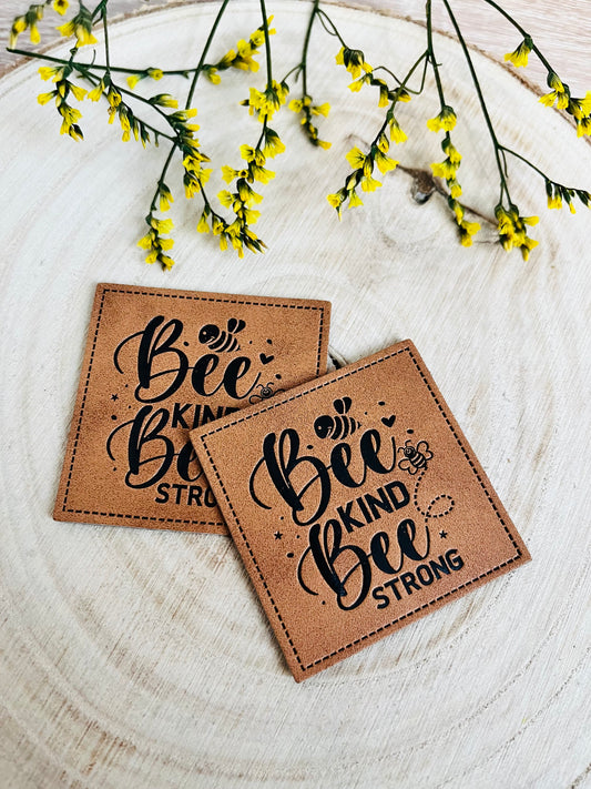 braunes kunstlederlabel mit dem spruch bee kind bee strong und kleinen bienchen abgebildet