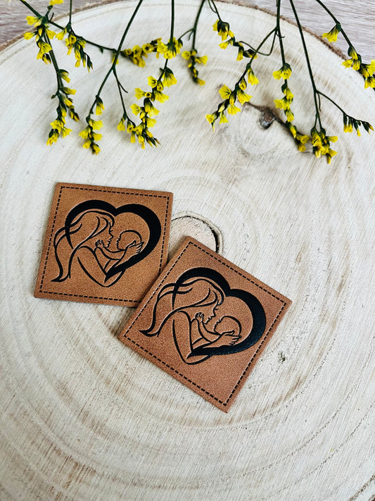 braunes kunstlederlabel mit einer mutter mit ihrem baby in einem herz vereint