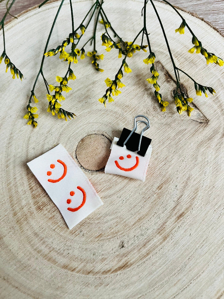 weisses Weblabel mit einem lächelndem Smiley in orangener Farbe