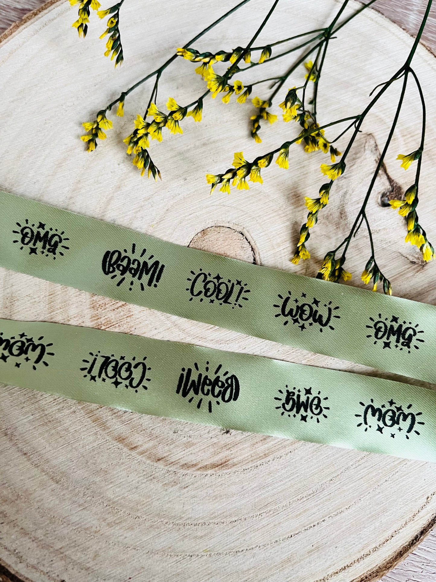 schönes grünes Satinband mit den fortlaufenden Motiven OMG BÄÄM Cool und WOW, Breite 2 Zentimeter.
