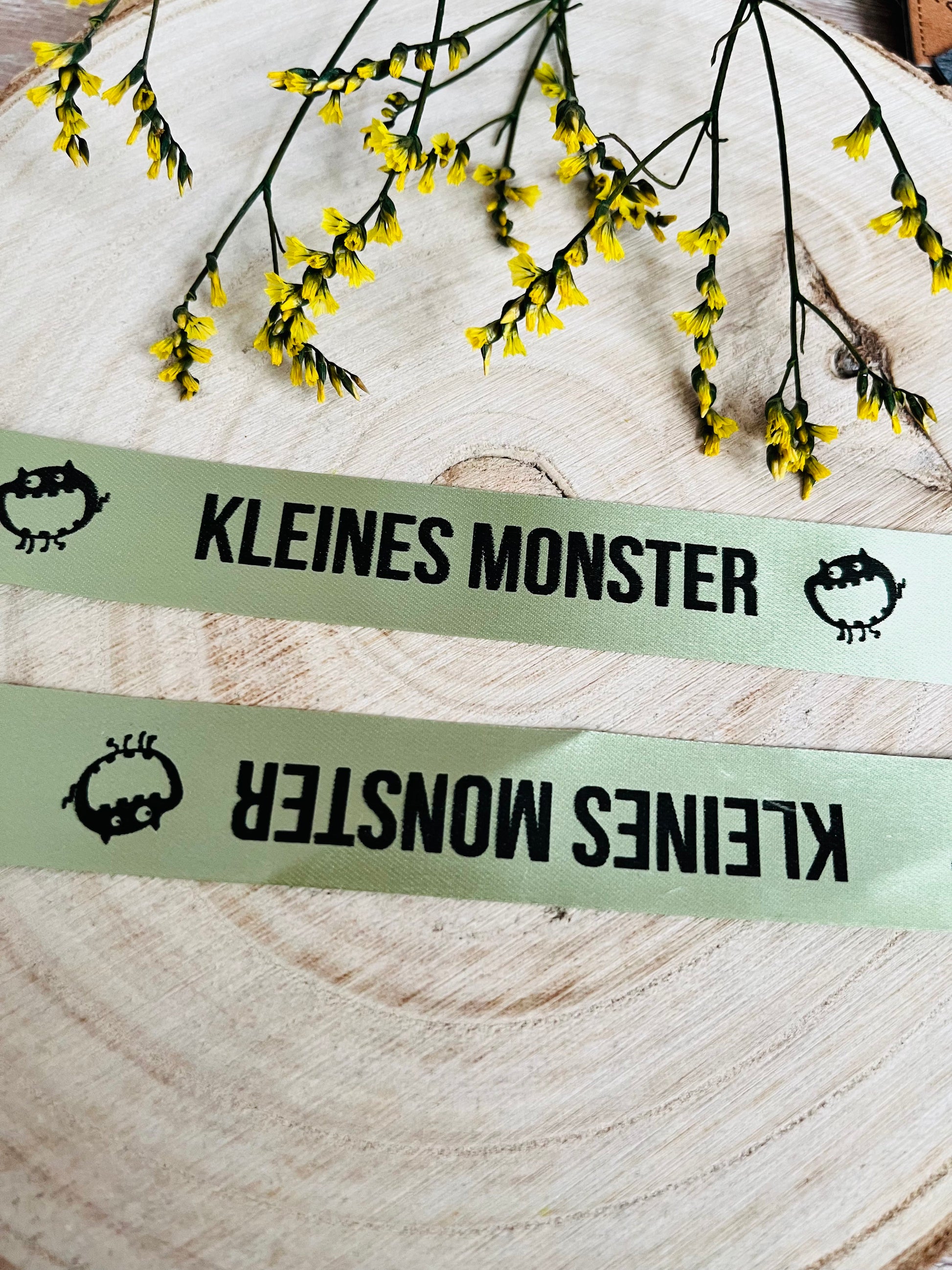 hellgrünes Satinband mit dem fortlaufenden Spruch Kleines Monster