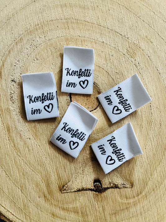 weisses Weblabel mit dem Spruch Konfetti im und einem herzsymbol in schwarz