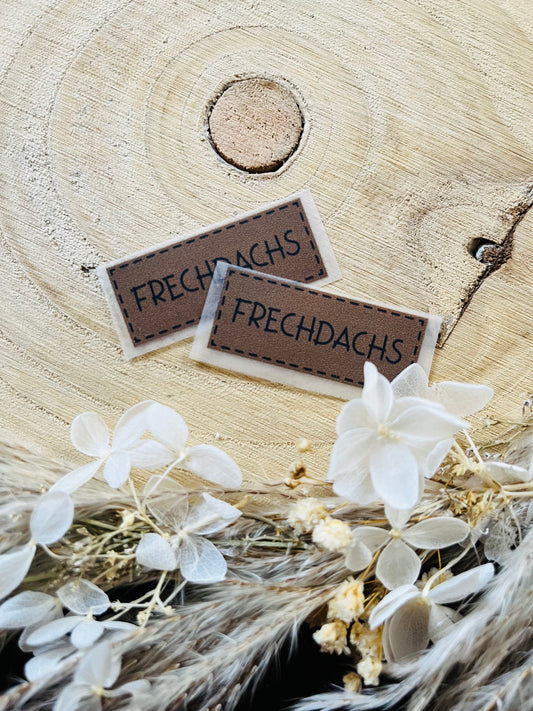 braunes Bügellabel mit dem Spruch Frechdachs