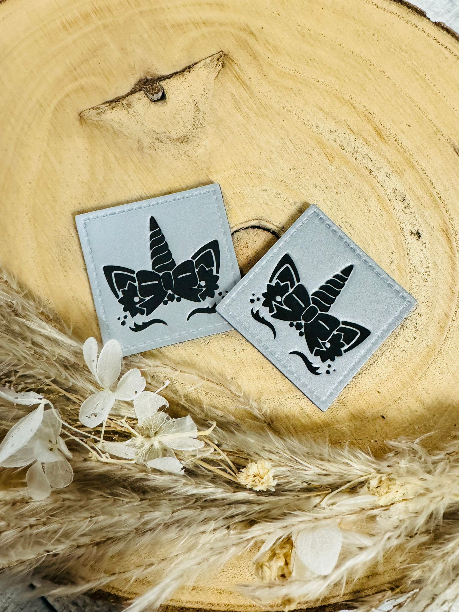 silbergraues reflektierendes Kunstlederlabel  mit einem niedlichen Einhorn Gesicht