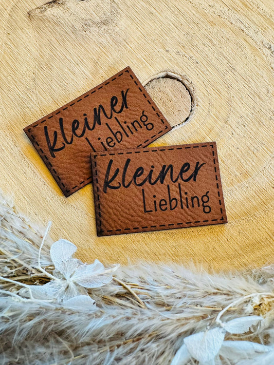 braunes superweiches Kunstlederlabel mit dem Spruch kleiner Liebling