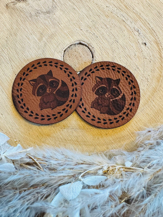 braunes rundes superweiches Kunstlederlabel mit einem kleinen Waschbär abgebildet