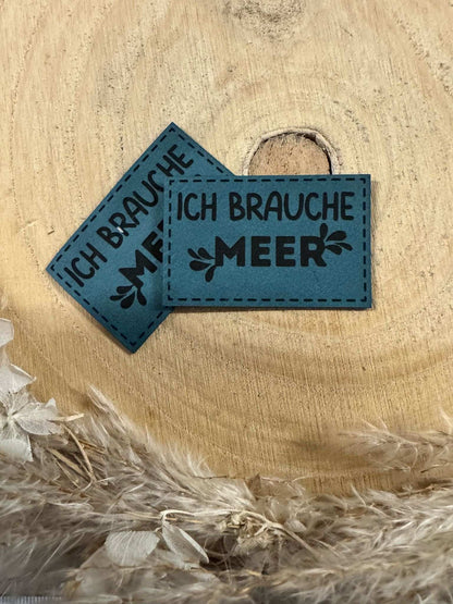 exclusives superweiches Kunstlederlabel in Türkis mit dem Spruch Ich brauche Meer