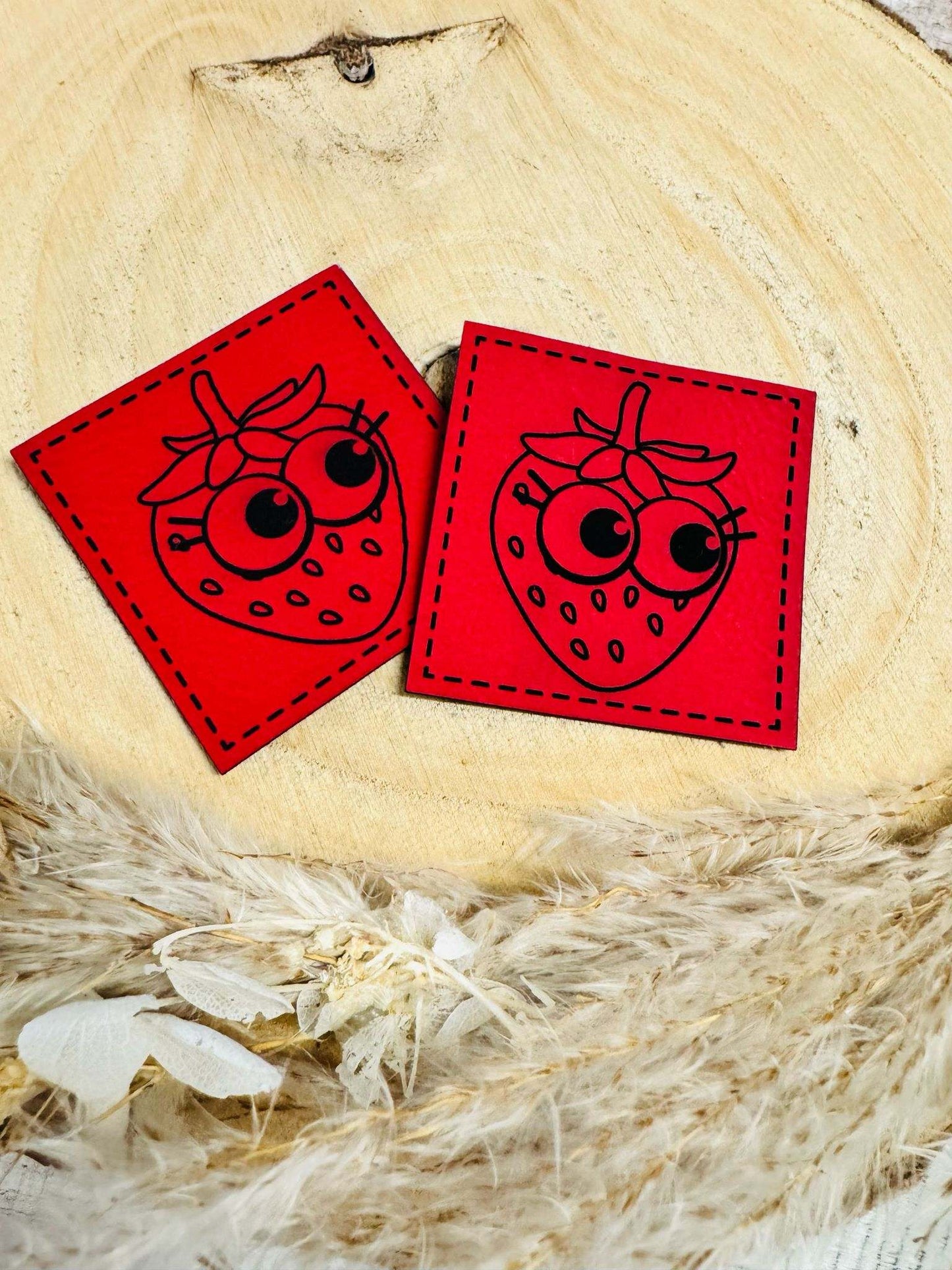 superweiches rotes Kunstlederlabel mit einer frechen Erdbeere abgebildet