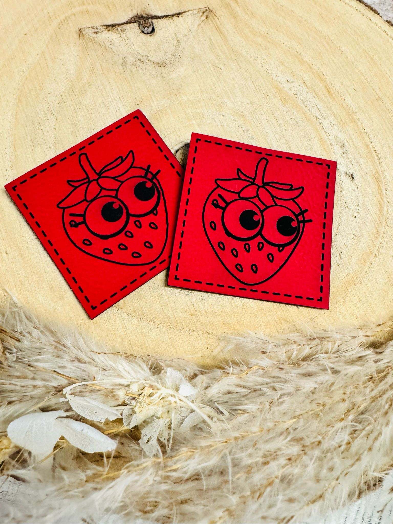 superweiches rotes Kunstlederlabel mit einer frechen Erdbeere abgebildet