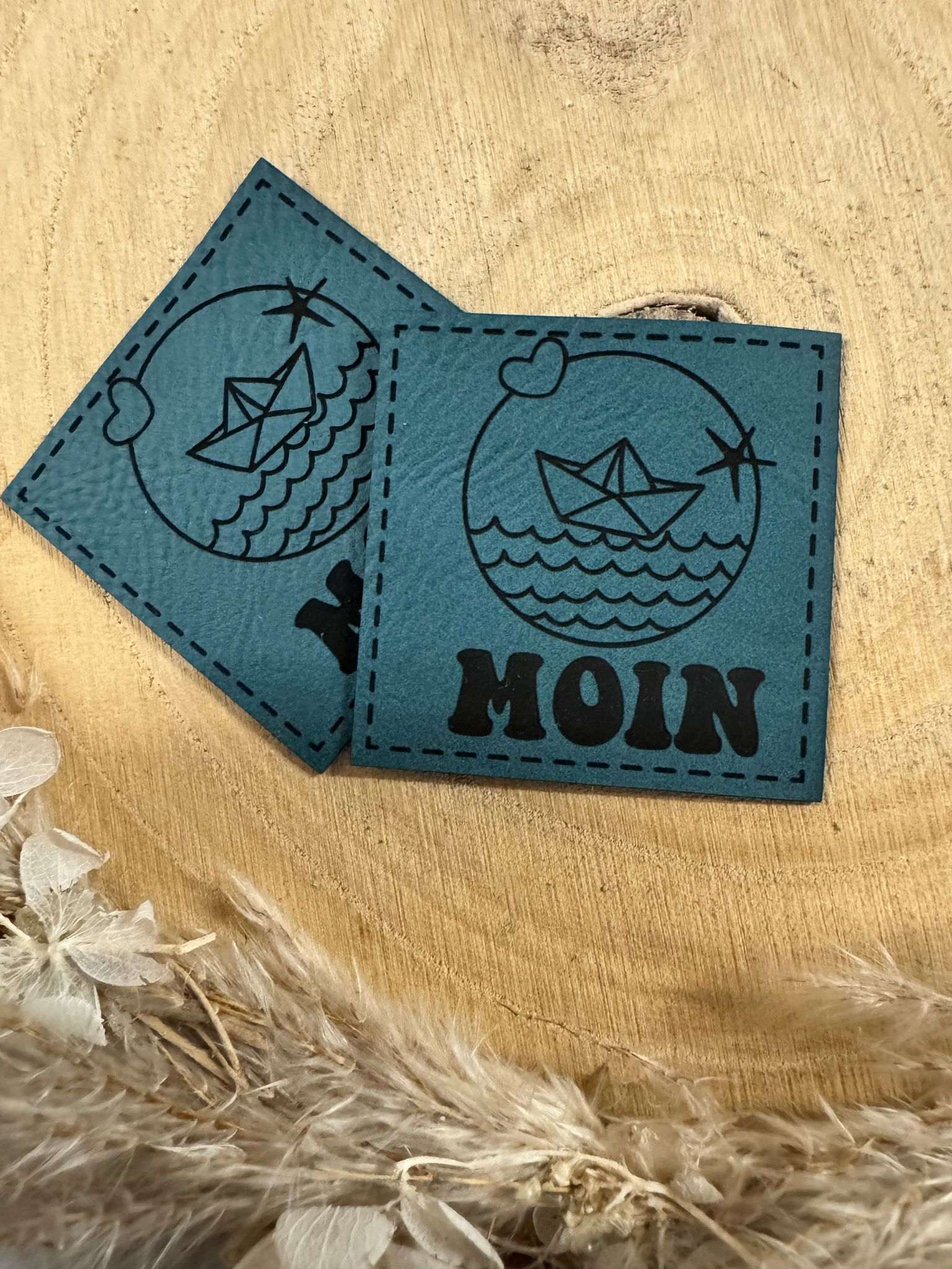 exclusives superweiches tealblaues Kunstlederlabel mit dem Spruch MOIN und maritimen Motiven