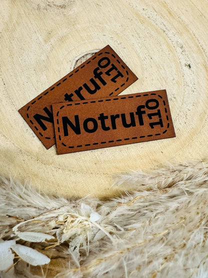 superweiches braunes Kunstlederlabel mit dem Spruch Notruf 110