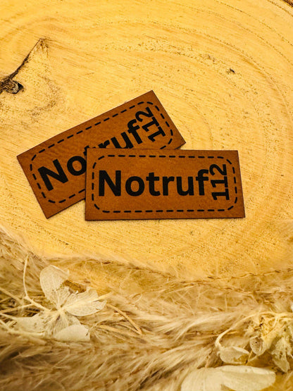 superweiches braunes Kunstlederlabel mit dem Spruch Notruf 112