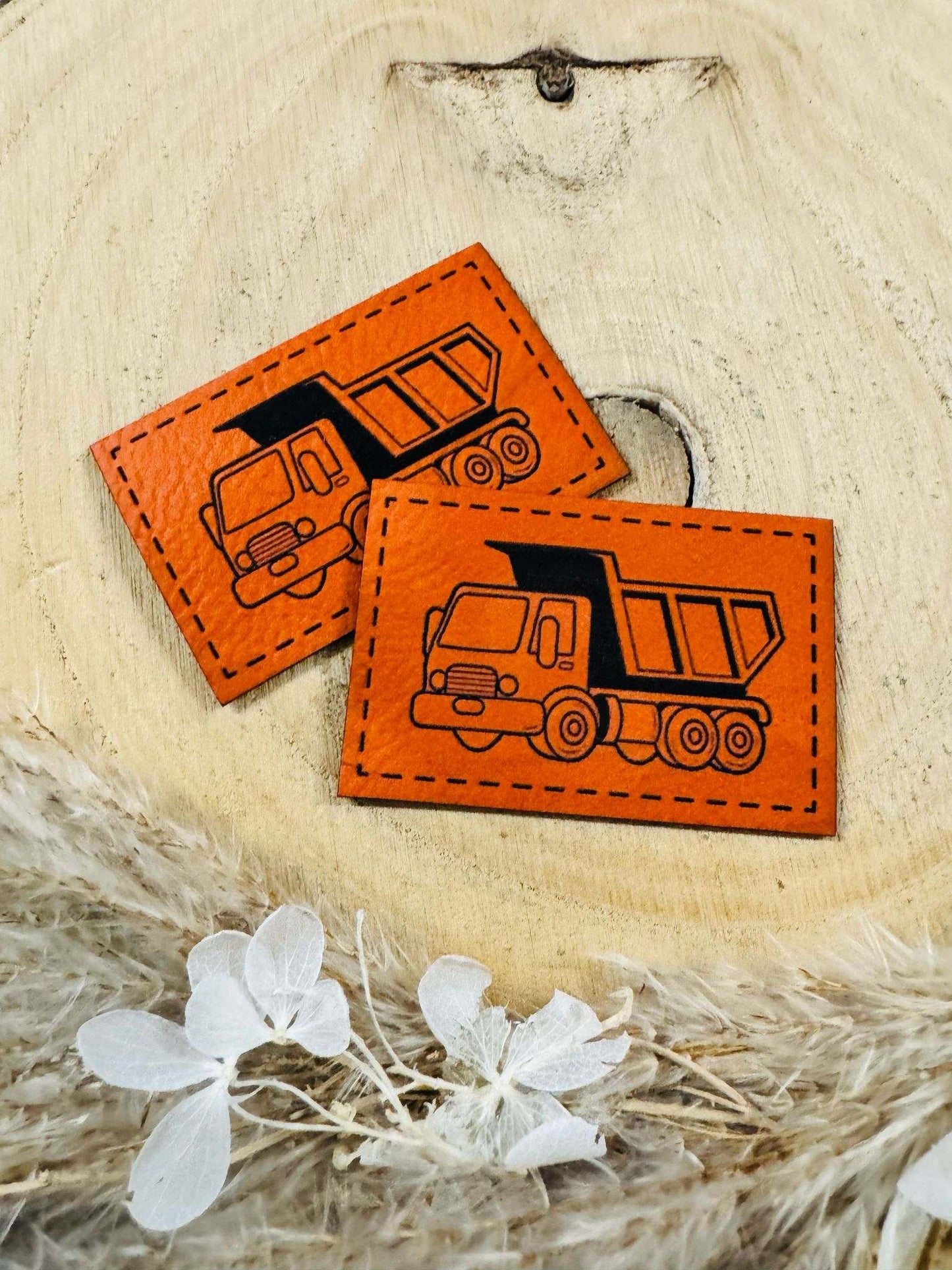 exclusives superweiches Kunstlederlabel in Orange mit einem Kipplaster abgebildet