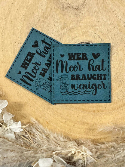 exclusives superweiches türkises Kunstlederlabel mit dem Spruch Wer Meer hat braucht weniger mit maritimen Motiven