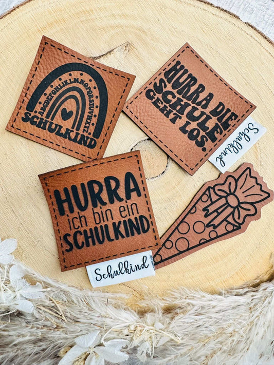 ein schönes Labelset zum Schulanfang mit vier braunen Kunstleder Labeln und zwei weissen Weblabeln mit verschiedenen  Sprüchen und Motiven