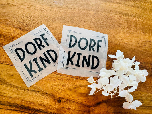 tolles Bügellabel mit dem Spruch Dorf Kind in schwarzen Buchstaben